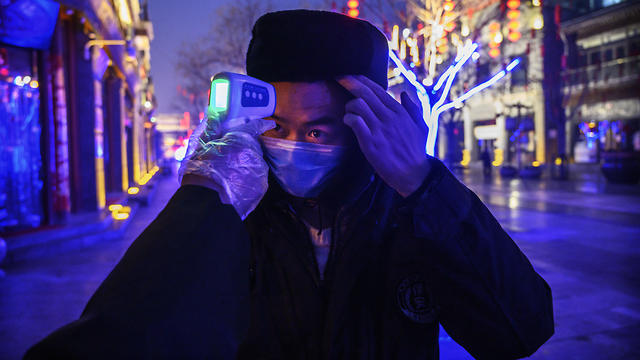בודקים אנשים ברחובות בייג'ינג' מחשש לנגיף הקורונה (צילום: Getty Images)