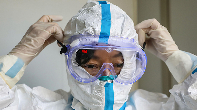 רופא מלביש מסכה בית חולים ווהאן סין נגיף קורונה (צילום: AFP)