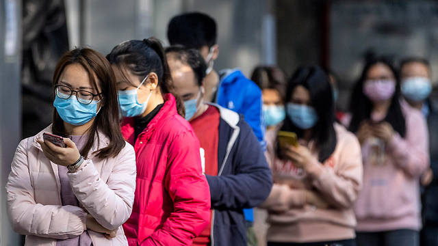 אנשים עומדים בתור אחרי שזכו בהגרלה לקניית מסכות בבית מרקחת ב גואנגג'ואו סין (צילום: EPA)