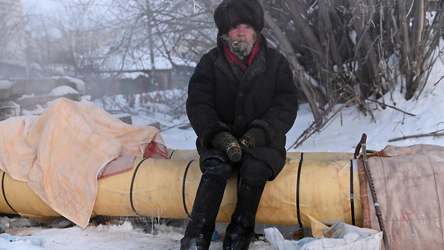 להיות הומלס חסר בית ב סיביר רוסיה אולג יושב על צינור חם (צילום: רויטרס)