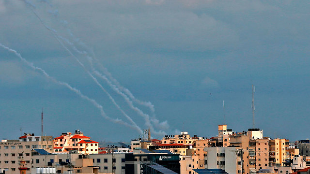 שבילי עשן מרקטות שנורו על ידי חמושים פלסטינים בעיר עזה (צילום: AFP)