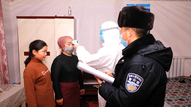 Китайская полиция сопровождает медиков при проверке в округе Алтай. Фото: EPA 