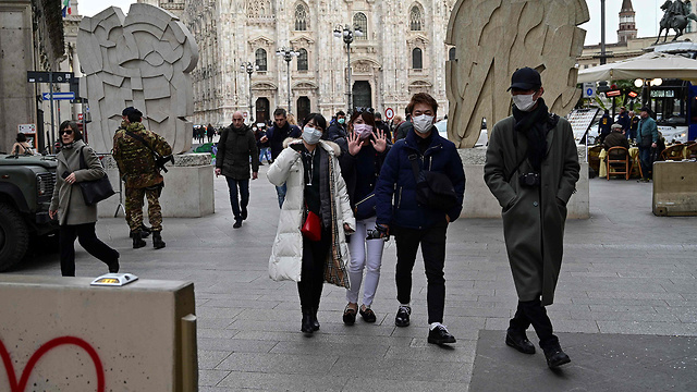תיירים עם מסכה ב מילאנו איטליה נגיף קורונה (צילום: AFP)