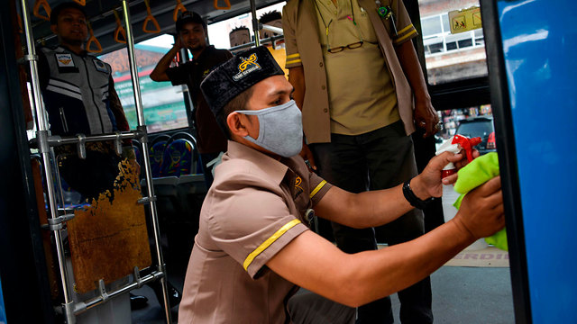 אוטובוס אוטובוסים ניקיון חיטוי מניעה וירוס קורונה נגיף הקורונה  אינדונזיה (צילום: AFP)
