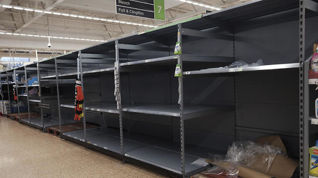 מדפים ריקים בסופרמרקט בלונדון בגלל נגיף הקורונה (צילום: AP)