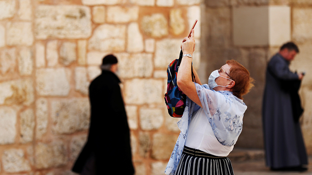אנשים עם מסכות בעיר העתיקה בירושלים (צילום: רויטרס)
