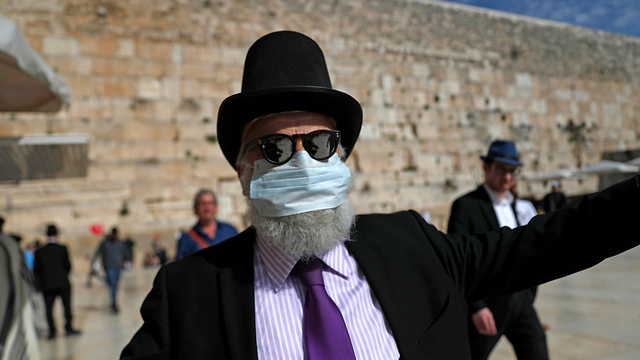 איש אם מסכת פנים בגלל הקורונה בכותל המערבי בירושלים (צילום: EPA)