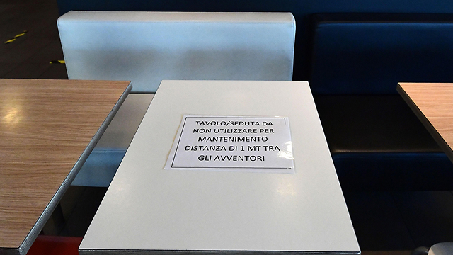 איטליה נגיף קורונה שולחן חציצה במסעדת מזון מהיר ב קסלפוסטרלניו דרומית מזרחית למילאנו (צילום: AFP)