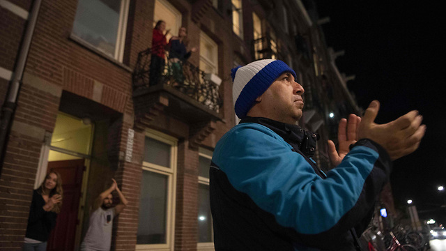 הולנד אמסטרדם נגיף קורונה מוחאים כפיים מ מרפסות כניסות בתים ל רופאים (צילום: AFP)