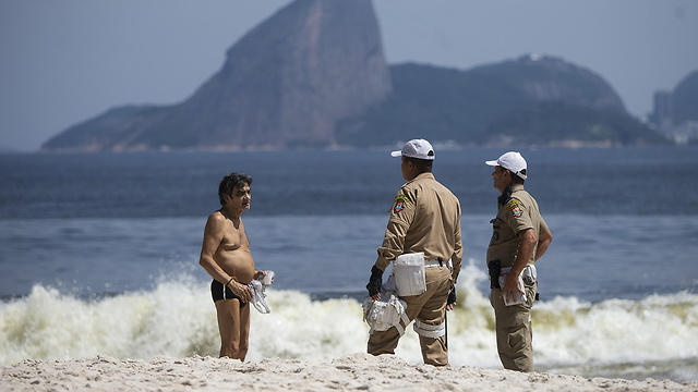 כוחות אבטחה מבקשים ממתרחץ לצאת מהים לעזוב את החוף ב ניטרוי ברזיל (צילום: gettyimages)