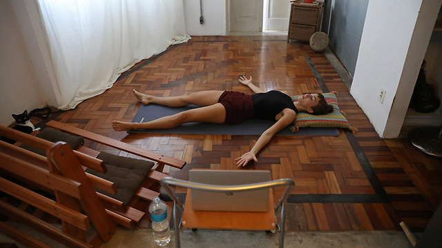 מורה ל יוגה מעבירה שיעורים מהבית ב ריו דה ז'ניירו ברזיל (צילום: רויטרס)