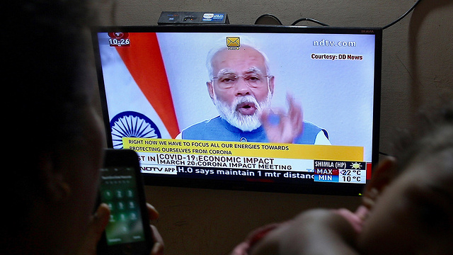 אנשים צופים ב נאום של ראש ממשלת הודו רנדרה מודי (צילום: EPA)