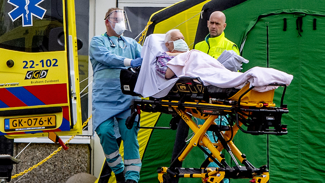 קשיש מובל ב אלונקה ל בית חולים שדה ב איינדהובן הולנד נגיף קורונה הקורונה (צילום: MCT)