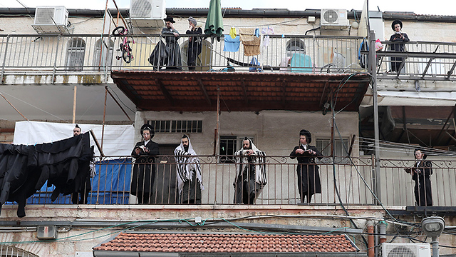 מתפללים במרפסות בשכונת מאה שערים (צילום: EPA)