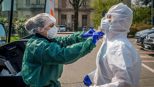 צוותי רפואה ב מילאנו איטליה נגיף קורונה מסכה חליפת מגן (צילום: MCT)
