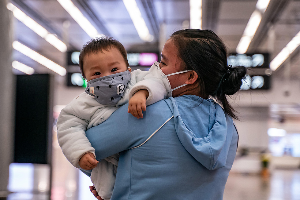 אישה עם תינוק בתחנת רכבת מסיכות  (צילום: gettyimages)