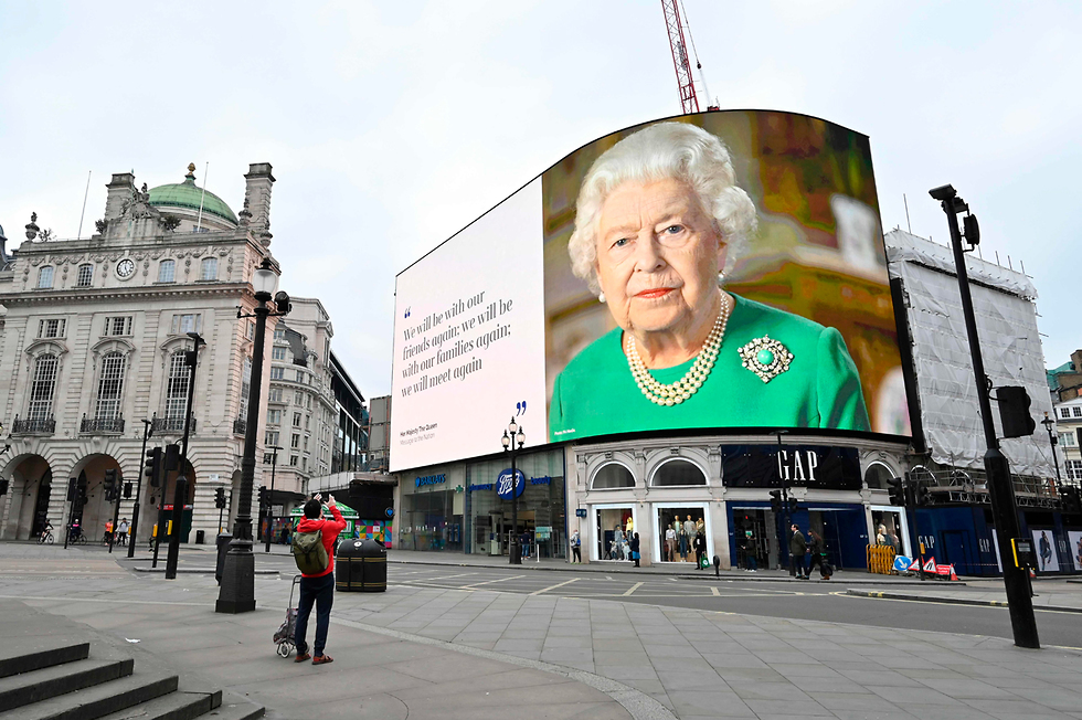 שלט חוצות של המלכה אליזבת כיכר פיקדילי לונדון נגיף קורונה בריטניה (צילום: AFP)