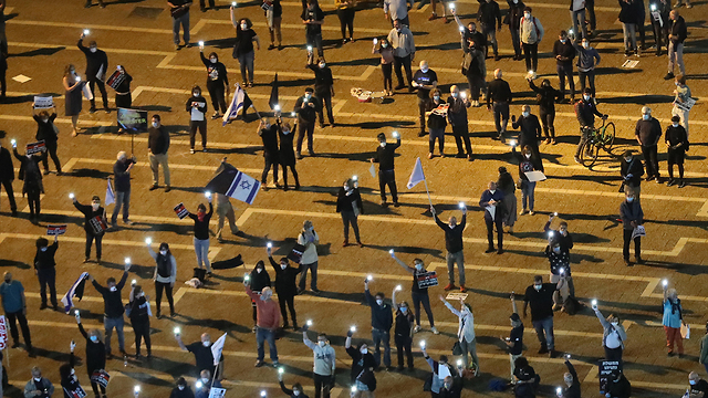 סימון שמירת מרחק של שני מטר במחאת הדלגים השחורים בכיכר רבין (צילום: EPA)
