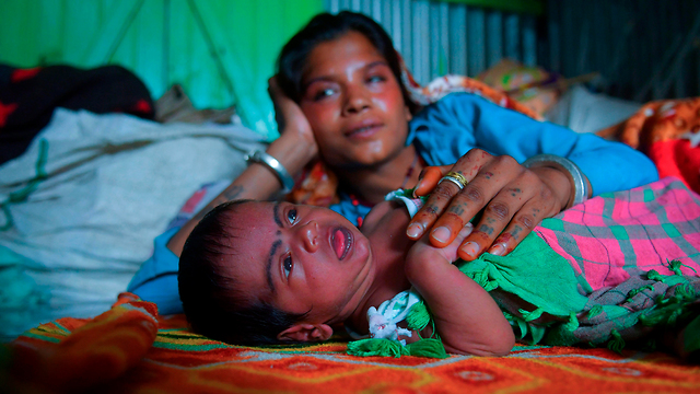 נגיף קורונה הורים קוראים לילדים על שם הנגיף תינוק בשם סגר עם אמו הודו (צילום: AFP)