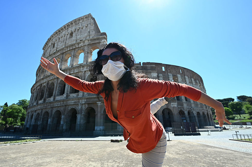 יוגה עם מסכה מול הקולוסיאום קולוסיאום ב רומא איטליה הקלות (צילום: AFP)