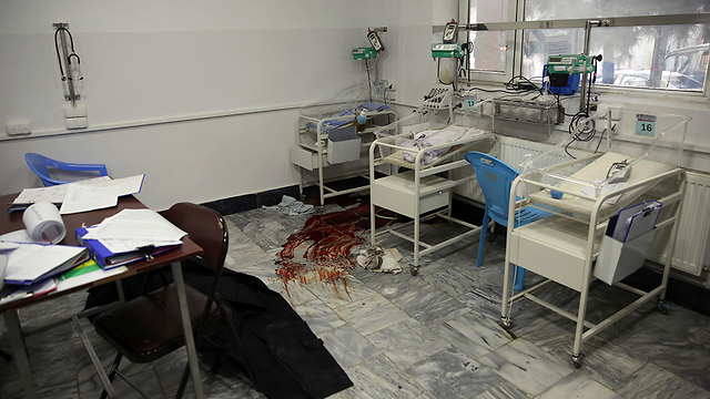 אפגניסטן קאבול פיגוע בית חולים ליולדות חייל מפנה תינוק (צילום: EPA)