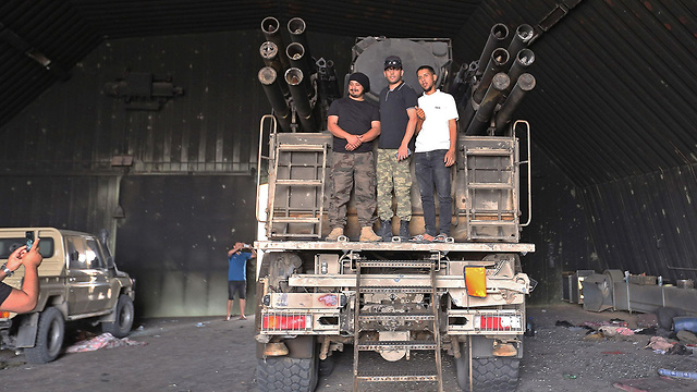 לוחמים שנאמנים לממשלת לוב ליד בסיס צבאי בפרברי טריפולי (צילום: AFP)