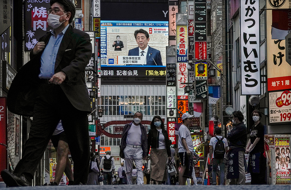 שינזו אבה ראש ממשלת יפן על מסך ב טוקיו (צילום: EPA)