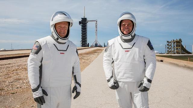 מדגמנים עתידנות. האסטרונאוטים בנקן (מימין) והארלי בחליפות החדשות על רקע כן השיגור עם טיל פלקון  (צילום: נאס