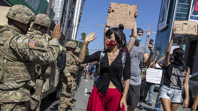 מפגינה נותנת כיף לאיש המשמר הלאומי בהוליווד (צילום: TNS)