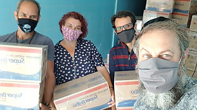 הרב גילברטו ונטורה (מימין), ומתנדבים שנערכים לחלוקה של חבילות מזון לתושבים נזקקים בסאו פאולו שבברזיל (באדיבות 