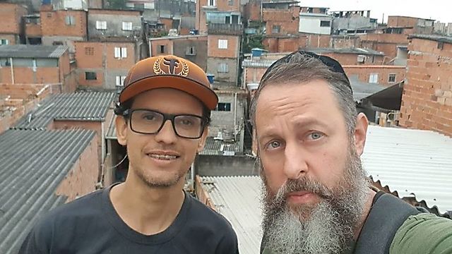 הרב גילברטו ונטורה ומתנדב בפאבלה של סאו פאולו (באדיבות 