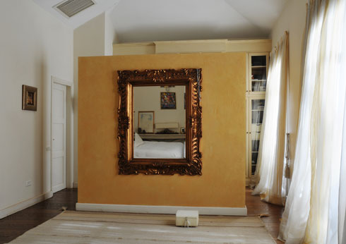 קיר  "free standing" עם מראה מוזהבת בין חדר שינה לחדר ארונות מתאים למי שמחפש שילוב של זרימה ואלגנטיות. עיצוב: רחל סלע (צילום: שי אדם)