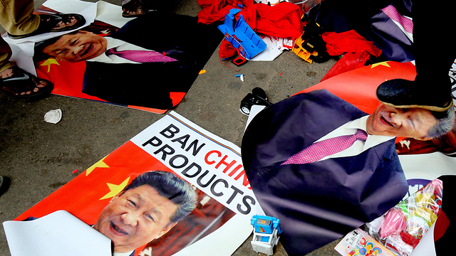 הודו מפגינים דורכים על תמונת נשיא סין שי ג'ינפינג ושורפים אותה (צילום: EPA)