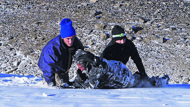 מגרלי (מימין) וחברו מחלצים את פתאל מבור השלג (צילום: Linh Vo)