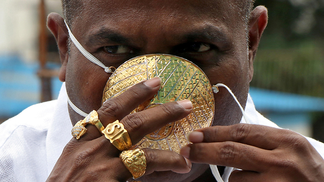 הודו גבר עם מסכה מ זהב  (צילום: רויטרס)