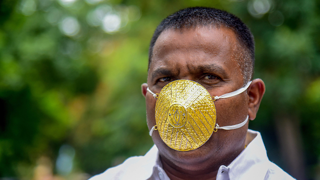 הודו גבר עם מסכה מ זהב  (צילום:AFP )