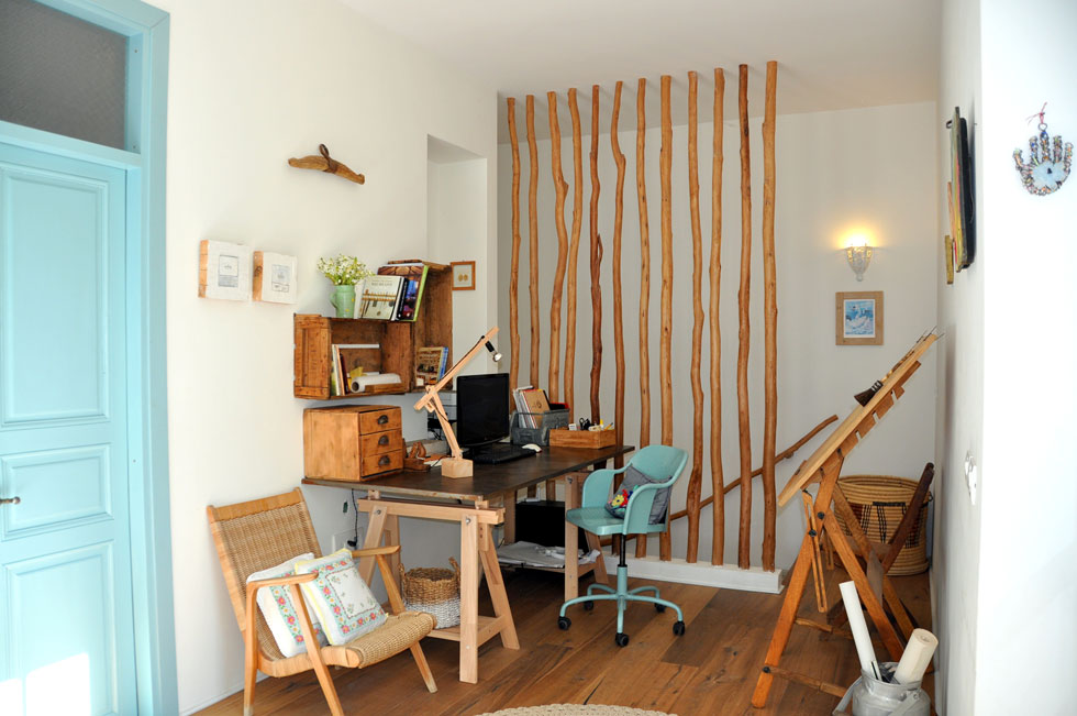 לצד החדר פינת העבודה של סידי, על טהרת רהיטים מעץ מלא. המדרגות יורדות אל חדר הבן במרתף, והמעקה עשוי גם כאן מענפי אקליפטוס (צילום: גלעד רדט)