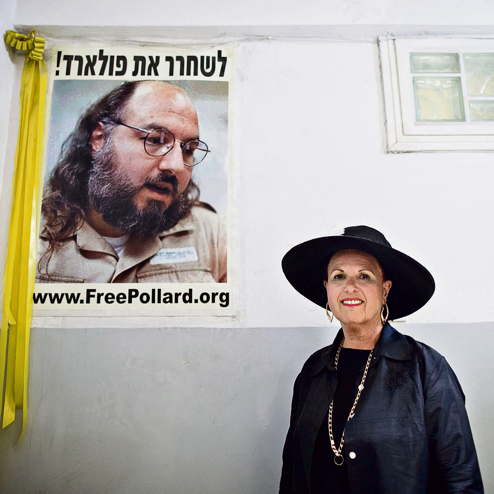 “היא הפכה לדמות ציבורית בגללי. באשמתי". אסתר פולארד על רקע כרזה לשחרור בעלה | צילום: אי.פי.איי