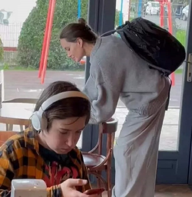 If only he would raise his head for a moment.  Angelina Jolie visits a cafe in Lvov, Ukraine (screenshot)