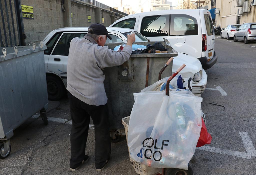 An elderly Israeli man searches in the trash   (Photo: Shaul Golan)