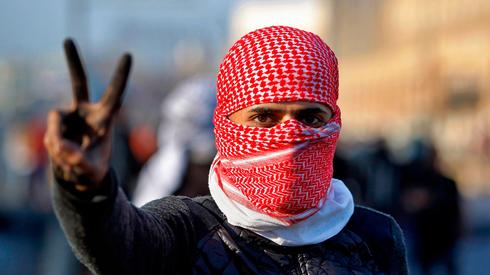 A protester in Najaf flashes the victory sign  (Photo: AP)