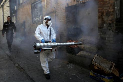 Iranian health worker disinfecting a Tehran street  (Photo: AP)