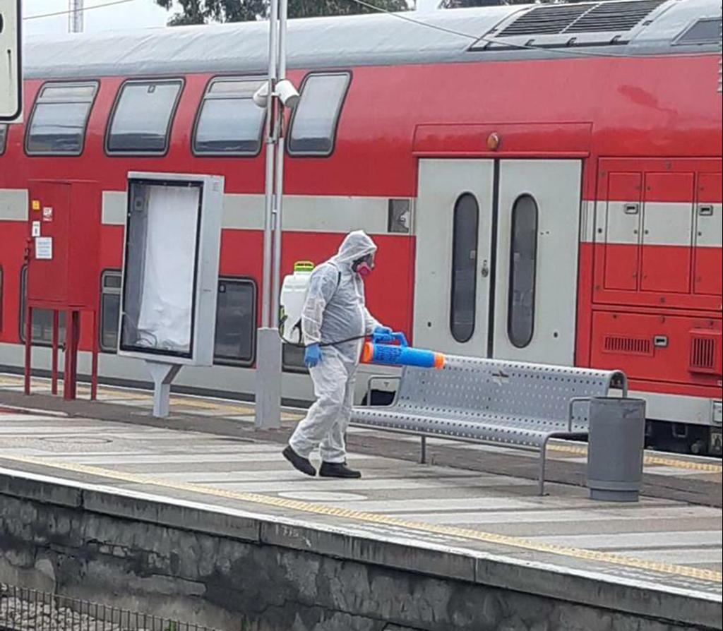 A worker disinfects a train platform  ()