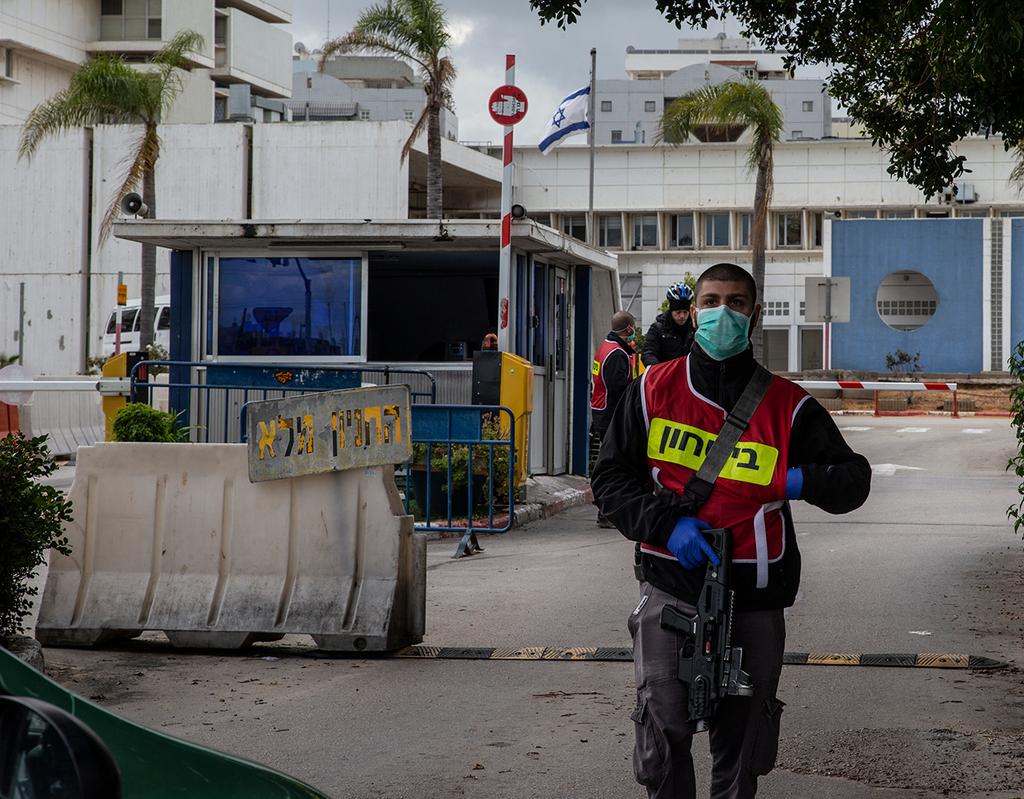 A guard wears a mask against coronavirus at the entrance to Wolfson Hospital in Holon ()