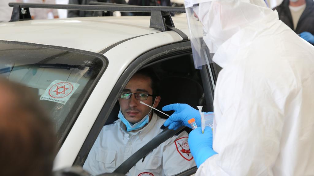 A healthcare official carries out a coronavirus test on a medic at a 'drive through' site in Jerusalem  ()