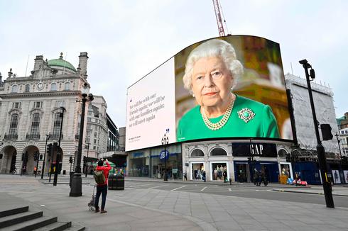 A poster of Queen Elizabeth and an excerpt from her recent address to the nation is displayed in coronavirus-hit central London  (Photo: AFP)