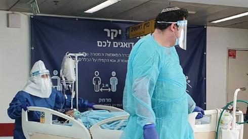 Medics in protective gear against coronavirus with a patient at Ichilov Hospital in Tel Aviv 