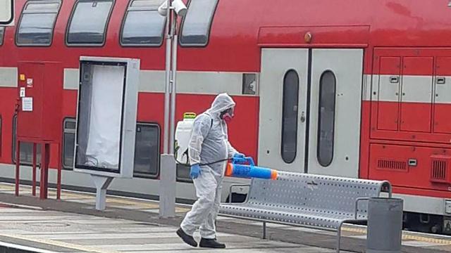Sanitation worker disinfecting a train station  ()