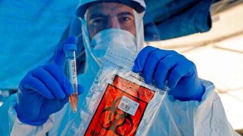 A health worker staffs a coronavirus testing facility in Ramat Hasharon, central Israel  (Photo: AFP)