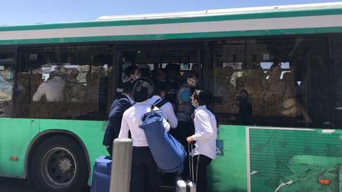 People line up to board a crowded bus  ()
